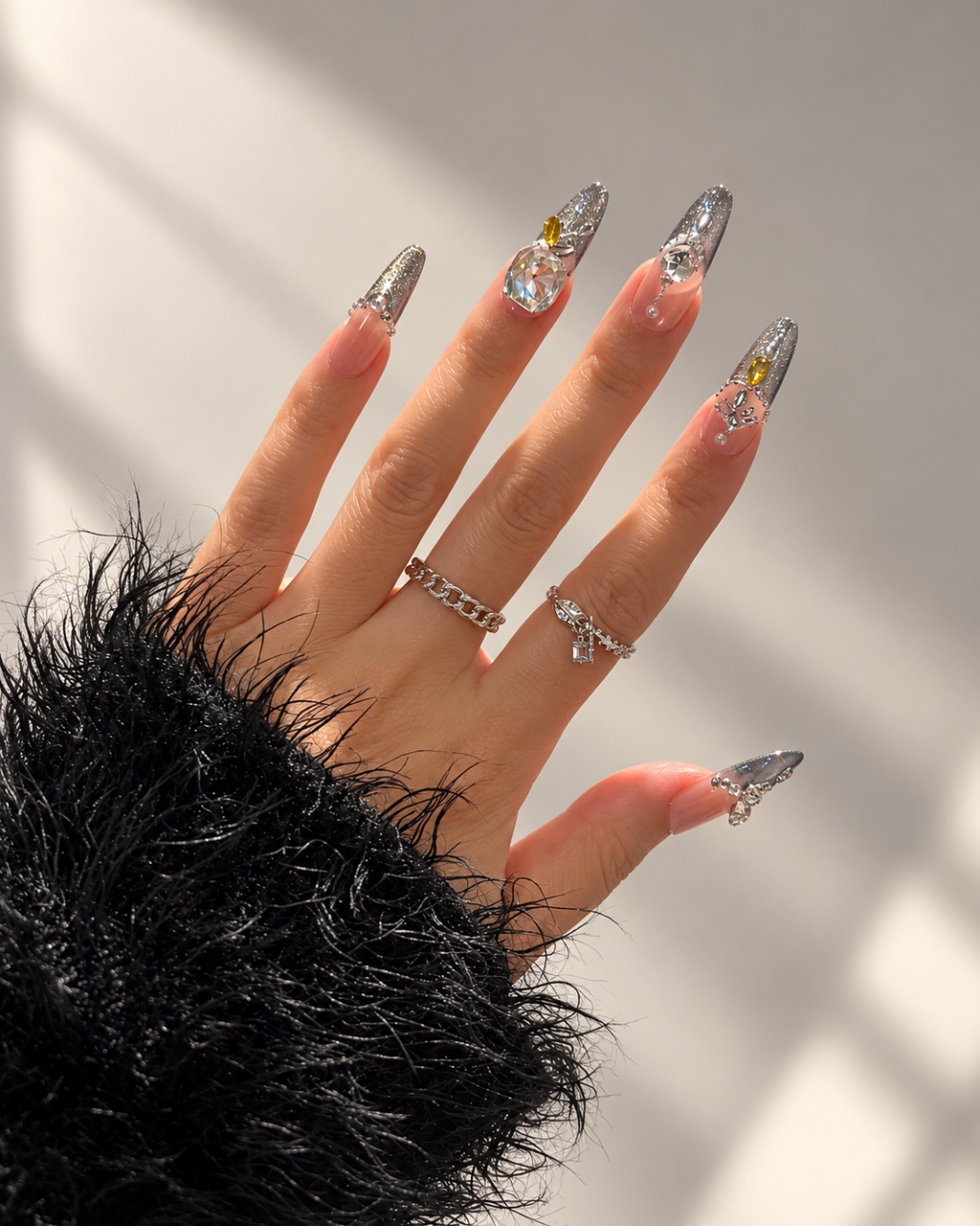 Handmade nude and smoky grey almond press-on nails with oversized iridescent crystals and rhinestone detailing