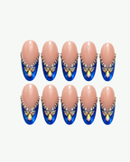 Handmade nude and navy blue press-on nails with iridescent butterfly crystals and rhinestone detailing